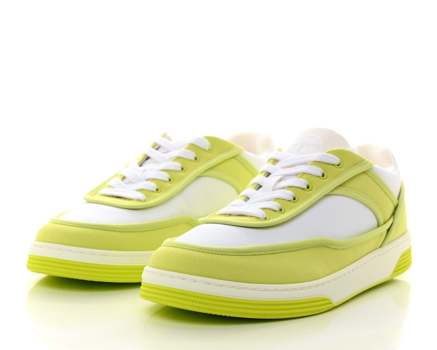 Pair of lime green sneakers with white laces on a white background