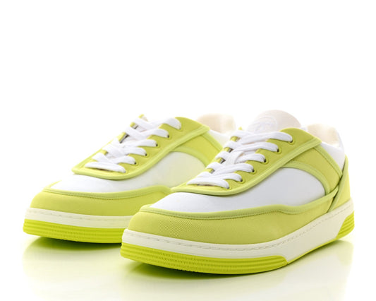 Pair of lime green sneakers with white laces on a white background